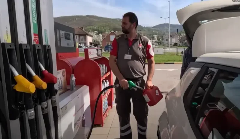 radnik na pumpi toči gorivo u rezervoar automobila