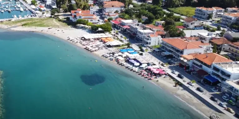 Pogled iz ptičije perspektive na Platamon i obalu sa plažom i restoranima.