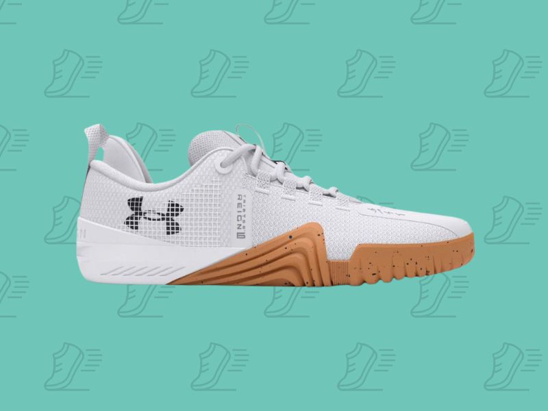 Under Armour Reign 6 patika u beloj boji sa gumenim đonom – dizajnirana za stabilnost i performanse tokom intenzivnih treninga.
