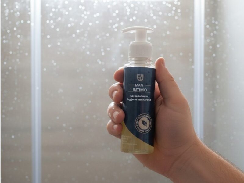 momak drži man intimo gel u ruci u tuš kabini