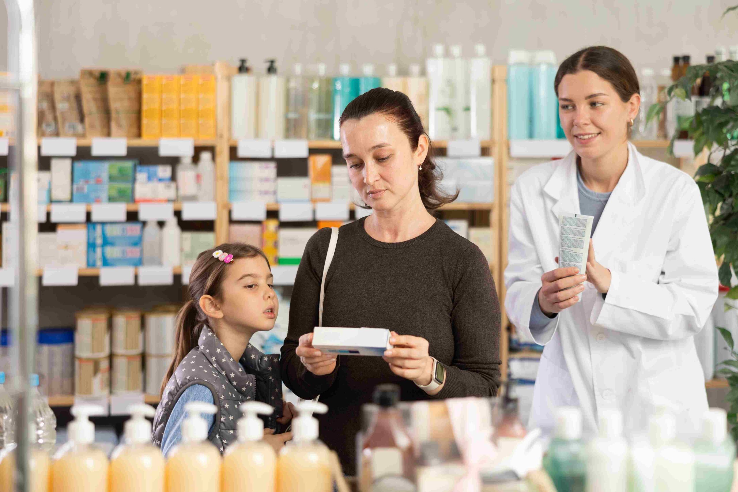 Majka sa detetom u apoteci razgovara sa farmaceutom