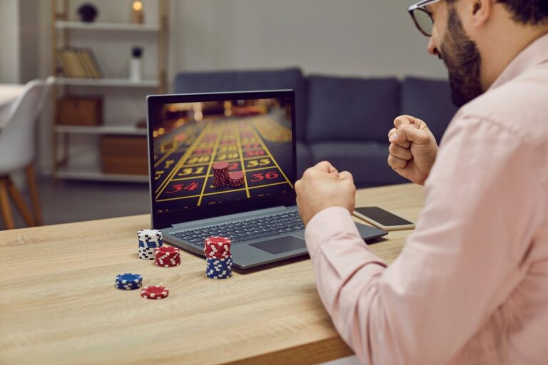 momak pođeđuje u kuckanju koje igra na laptopu i raduje se