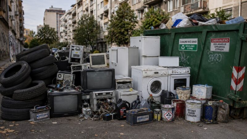 Auto-gume, stari televizori, računari, bela tehnika, akumulatori i kante sa farbom ostavljeni pored kontejnera u gradu.