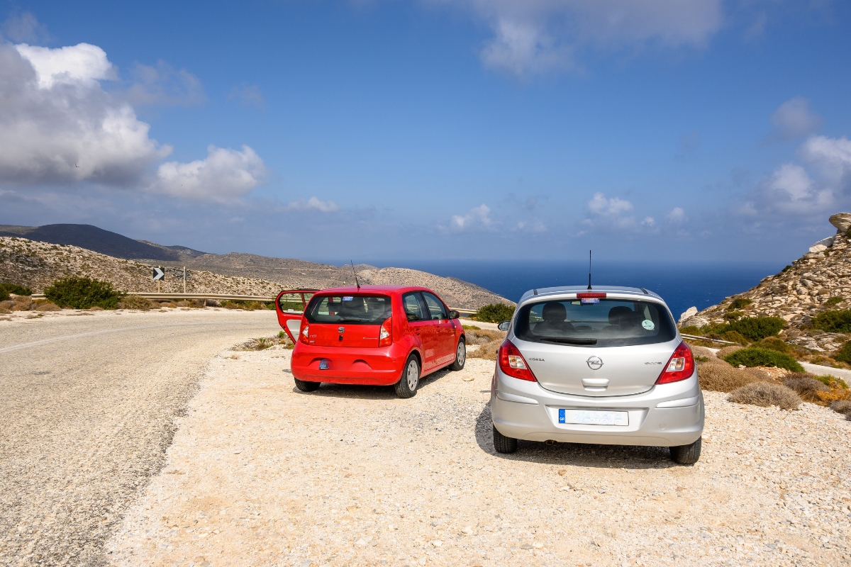 dva automobila parkirana pored mora